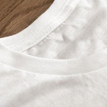 Load image into Gallery viewer, a close up of a white shirt on a wooden surface